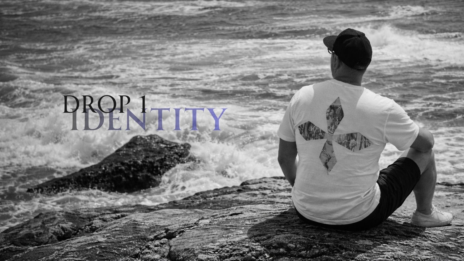 Pessoa sentada junto ao mar a usar t-shirt REEXIST com estampado cruz com anjo nas costas.